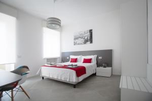 um quarto branco com uma cama grande e almofadas vermelhas em Suite Dreams in Verona em Verona