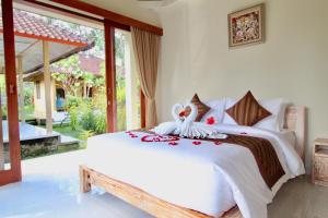 a bedroom with a white bed and a large window at With Love Bali in Gianyar