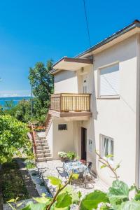 a house with a balcony and a table and chairs at House Gloria in Crikvenica