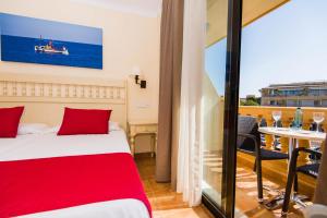 sypialnia z łóżkiem i balkonem ze stołem w obiekcie Bell Port Hotel w Cala Ratjada