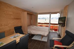 a room with a bed and a table and chairs at Le Lauranoure - 205 in L'Alpe-d'Huez