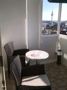 een tafel en stoelen in een kamer met een raam bij Deichstern in Bremerhaven