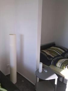 1 dormitorio con 1 cama y 1 mesa con lámpara en Deichstern, en Bremerhaven