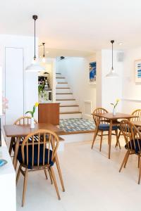 uma sala de jantar com mesas e cadeiras e uma escadaria em Trevose Harbour House em St. Ives