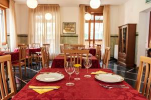 Martina Olba的住宿－Albergo Minetto，用餐室配有带盘子和玻璃杯的桌子