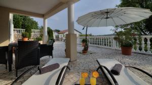 a patio with a table and an umbrella at Apartment Barbara in Senj