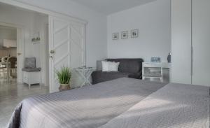a white bedroom with a bed and a couch at Apartment Barbara in Senj