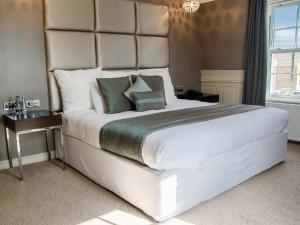 a large white bed in a room with a window at Cliff Hotel in Great Yarmouth