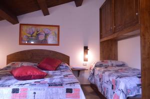 sypialnia z 2 łóżkami i czerwonymi poduszkami w obiekcie Vin e Turn w mieście Diamante