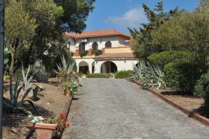 une allée menant à une grande maison blanche dans l'établissement Villa DESIDERIA B&B, à Capitana