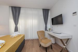 a bedroom with a desk and a bed with a chair at Gallery Rooms with Parking in Zadar +21 photos