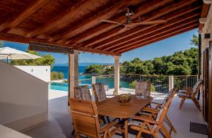 - une table et des chaises en bois sur une terrasse avec vue sur l'océan dans l'établissement Villa Nova Brac, à Sumartin
