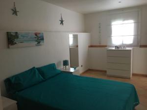 Schlafzimmer mit einem Bett mit grüner Tagesdecke in der Unterkunft apartamento pueblo rocio 80 in Nerja