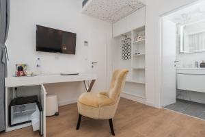 a room with a desk and a chair and a television at Gallery Rooms with Parking in Zadar