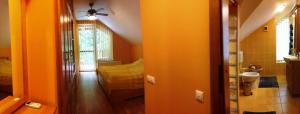 a room with orange walls and a bathroom with a bed at Sunset Beach Apartmanház in Balatonvilágos +36 photos