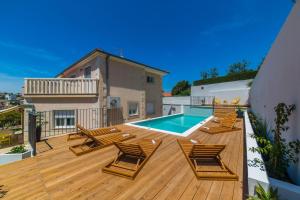 een terras met ligstoelen en een zwembad bij Villa Artea in Podstrana