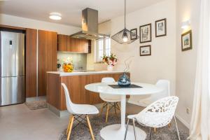 - une cuisine avec une table blanche et des chaises blanches dans l'établissement Villa Artea, à Podstrana