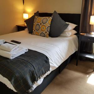 a bed with pillows and a blanket on it at Crown Inn in Rhayader