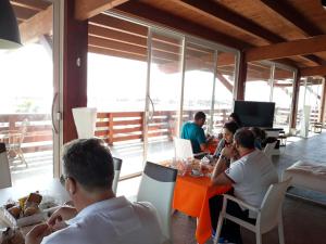 un grupo de personas sentadas en una mesa en un restaurante en Beach Club Ippocampo en Ippocampo