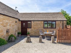 a house with a table and chairs in front of it at Milliner's Barn in Weston Subedge