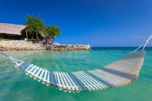a hammock in the water next to an island at Hotel Punta Faro in Isla Mucura