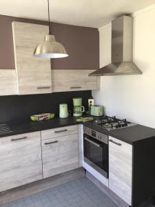 a kitchen with a black counter top and a stove at au calme à Etretat in Étretat