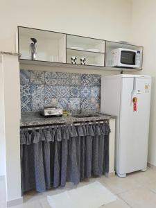 a kitchen with a counter and a refrigerator at Studio Ana Laura in São Paulo