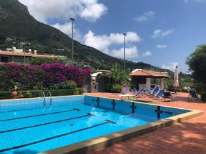 a swimming pool with a mountain in the background at Villa Moma con giardino, tennis e piscina panoramica in Forio d'Ischia