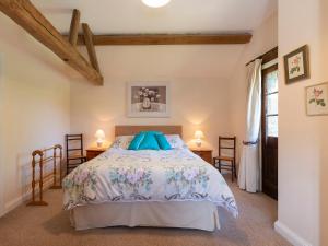 Weston SubedgeにあるSundial Cottageのベッドルーム1室(ベッド1台、テーブル2台付)
