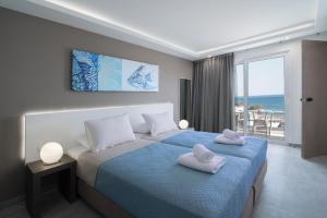 a bedroom with a bed with two towels on it at Coral Apartments in Ierapetra
