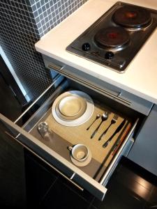 a kitchen with a stove with plates and utensils at Xinshikong Apartments- Abest Zhongshan Park No.1 in Shanghai