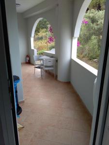 a hallway with an archway and a table and chairs at Afroditi Studios in Syvota