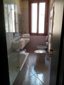 a bathroom with a tub and a toilet and a sink at Hotel Diana in Venice