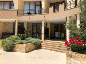 a building with flowers and plants in front of it at VP Luxor Studio in Sveti Vlas