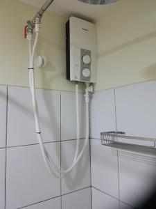 a shower with a white hose attached to a wall at KC Studio 1 at Horizons 101 Cebu in Cebu City