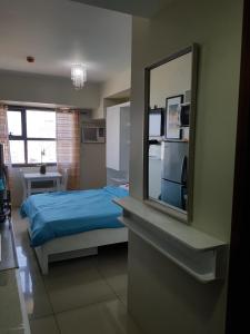 a bedroom with a bed and a mirror on the wall at KC Studio 1 at Horizons 101 Cebu in Cebu City