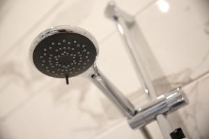 a shower head with a shower curtain attached to it at Latimer House in Bowness-on-Windermere