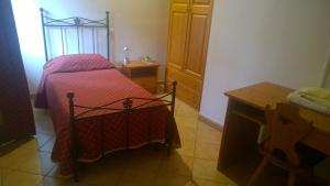 a small bedroom with a bed and a table at Locanda Nonno Puin in Ferrada di Moconesi