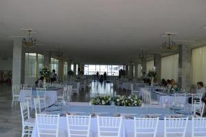 um salão de banquetes com mesas brancas e cadeiras brancas em Hotel Posada Arcos em San Juan de los Lagos