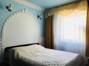 a bedroom with a white bed and a window at Ventspils Center Apartment in Ventspils