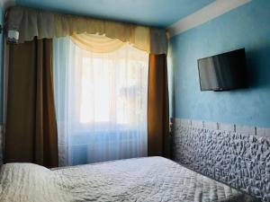 una camera con un letto e una finestra con televisore di Ventspils Center Apartment a Ventspils
