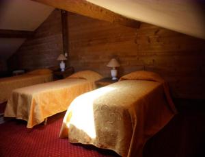 2 camas en una habitación con paredes de madera en Le Relais de l'Abbaye, en Tournus