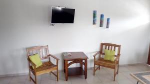 two chairs and a table with a tv on a wall at Michael's Tropical Suites in Scarborough