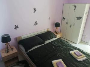 a bedroom with a bed with a green comforter and two lamps at Apartman BubaMara in Sveti Juraj