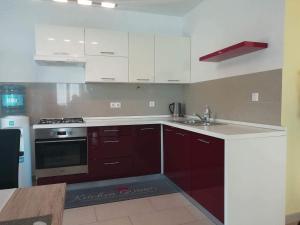 a kitchen with white cabinets and a stove top oven at Apartman BubaMara in Sveti Juraj