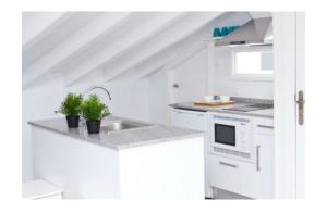 a white kitchen with a sink and a stove at LOFT Centro Ribadesella in Ribadesella