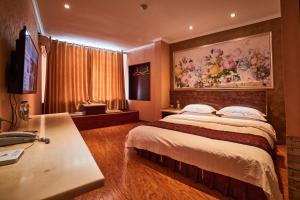 a hotel room with a large bed and a desk at Zhangye Liangmao Hotel in Zhangye