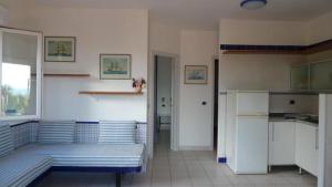 a room with two beds and a kitchen with a refrigerator at Residence Cala dei Peducelli in Capoliveri