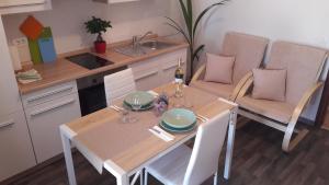 een keuken met een tafel en stoelen en een wastafel bij Apartman Dea in Crveni Vrh