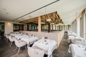 jadalnia z białymi stołami i krzesłami w obiekcie Park Hotel Bellevue w mieście Dobbiaco +31 zdjęć